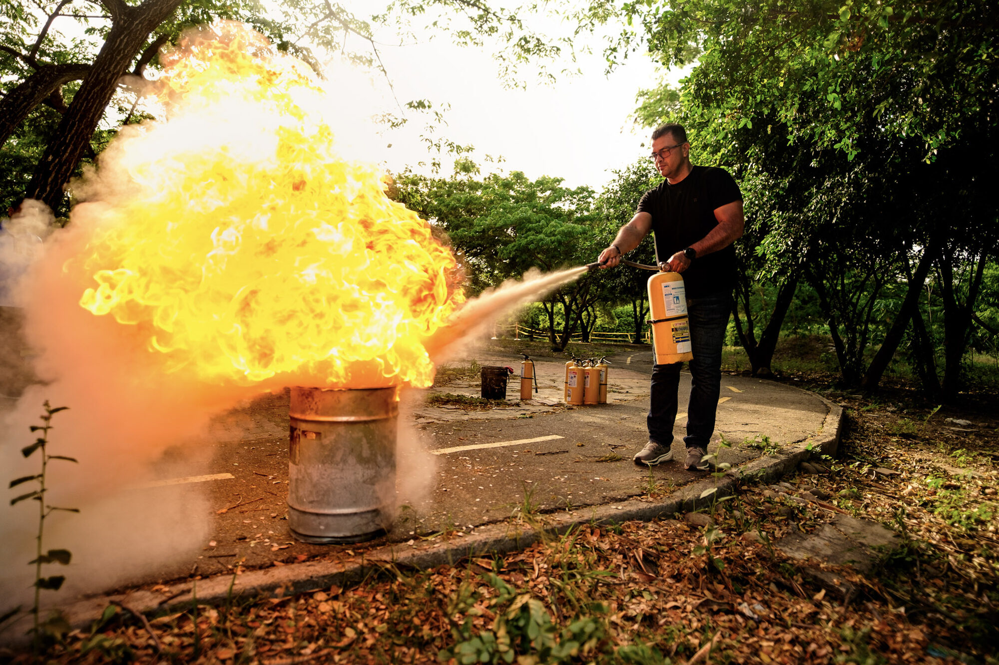 Instructor apagando fuego con extintor durante una capacitación práctica de PROSAFE